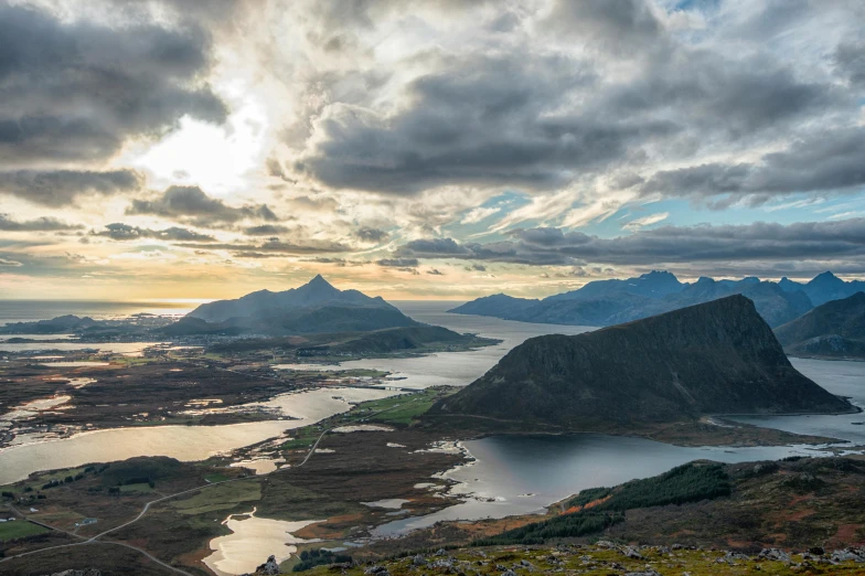 a couple of mountains overlooking the lake under cloudy skies