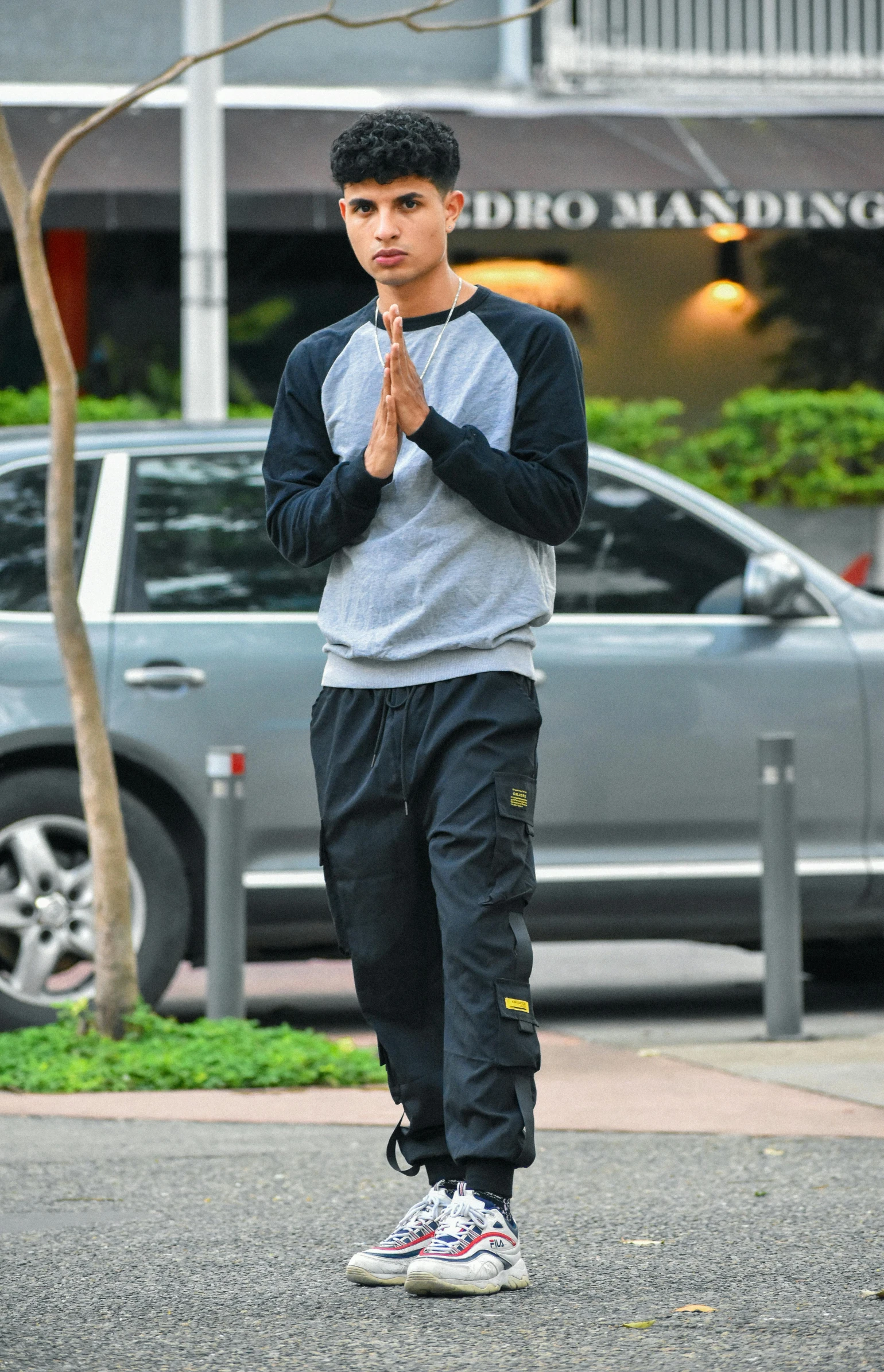 a man standing on the street with his hands folded