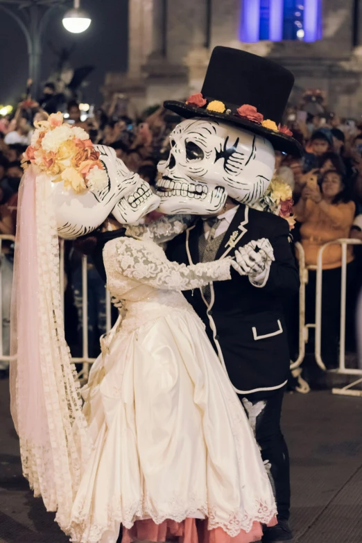 a couple in white wedding attire kissing and posing for a po