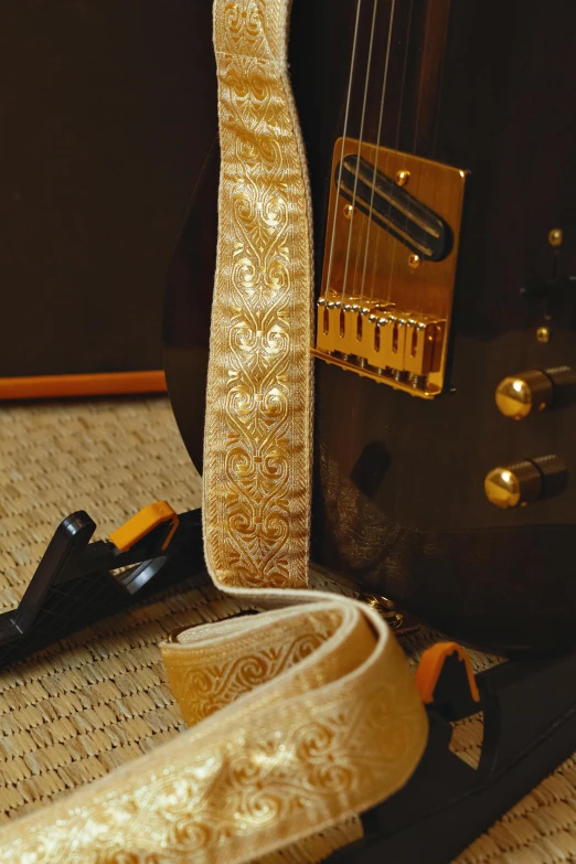 guitar straps, a gold guitar strap and some gold metallic guitar strings