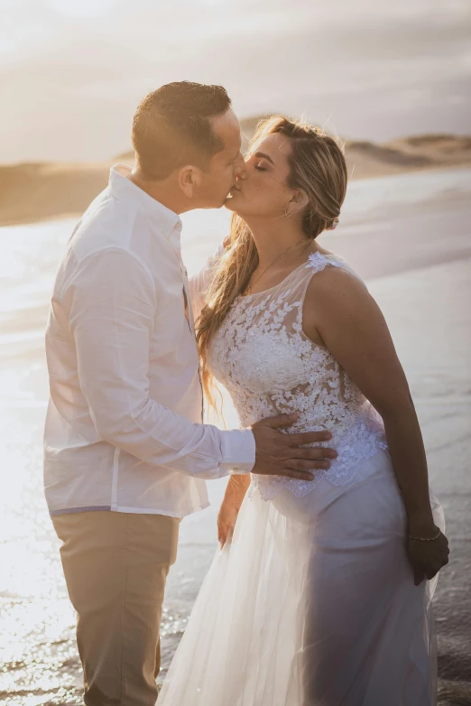 couple kissing while on the beach at sunset