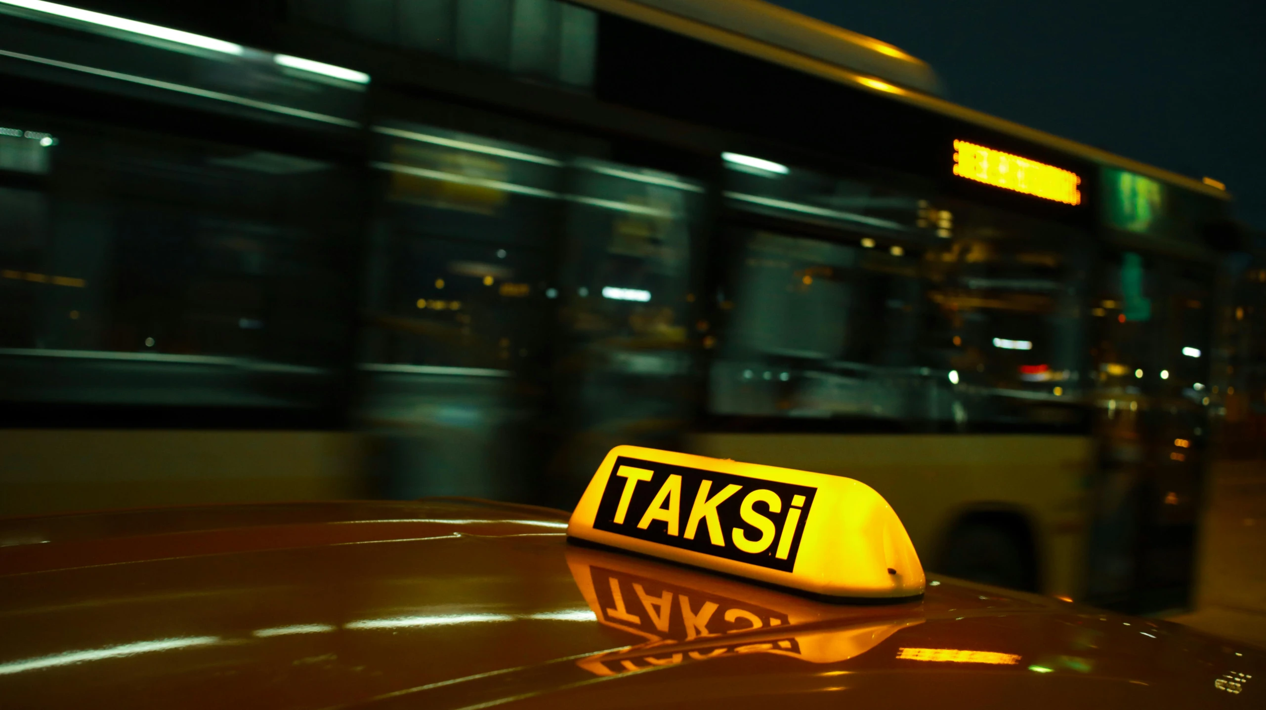 there is an advertit for taxis next to a bus