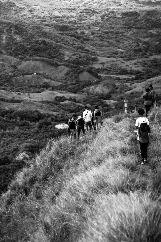 black and white pograph of several people walking uphill