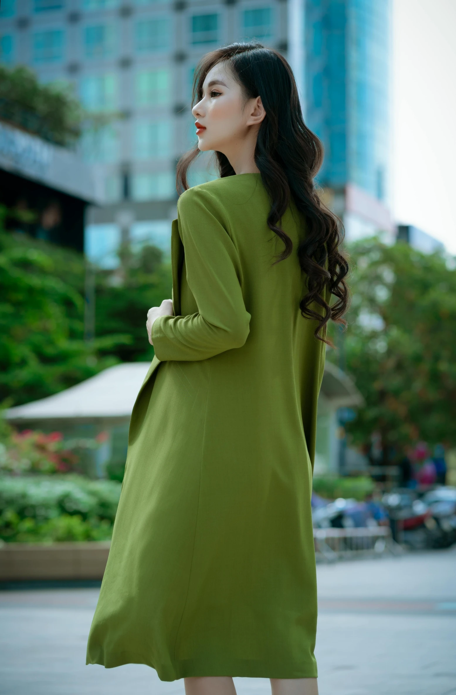 a woman is posing on the street wearing a long coat