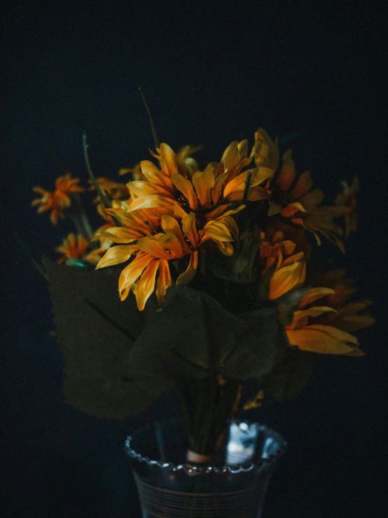 yellow flowers in a glass vase sitting on a table