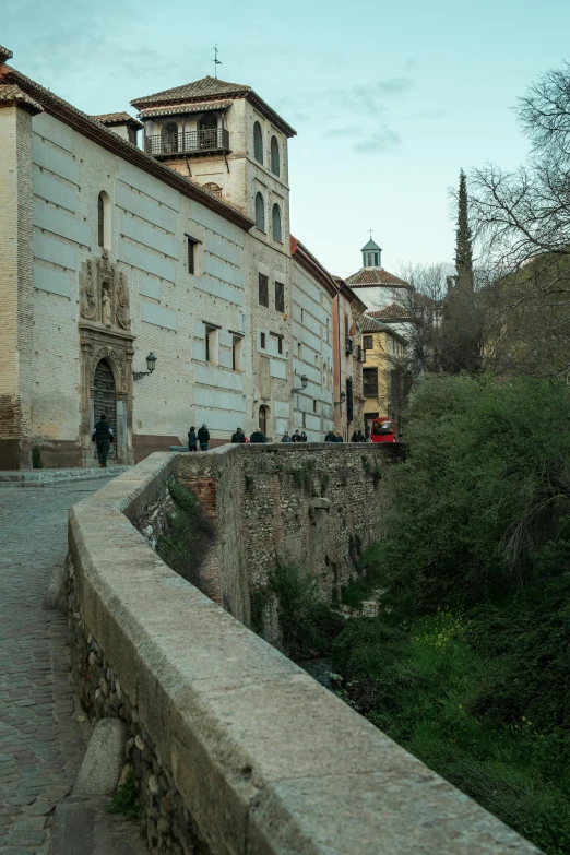 old building in the city center next to a wall and some vegetation