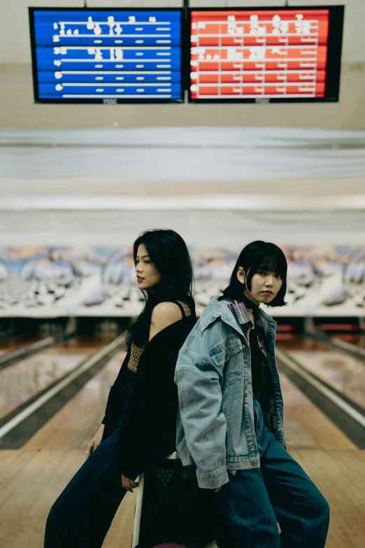 a man and woman standing together at the bowling alley