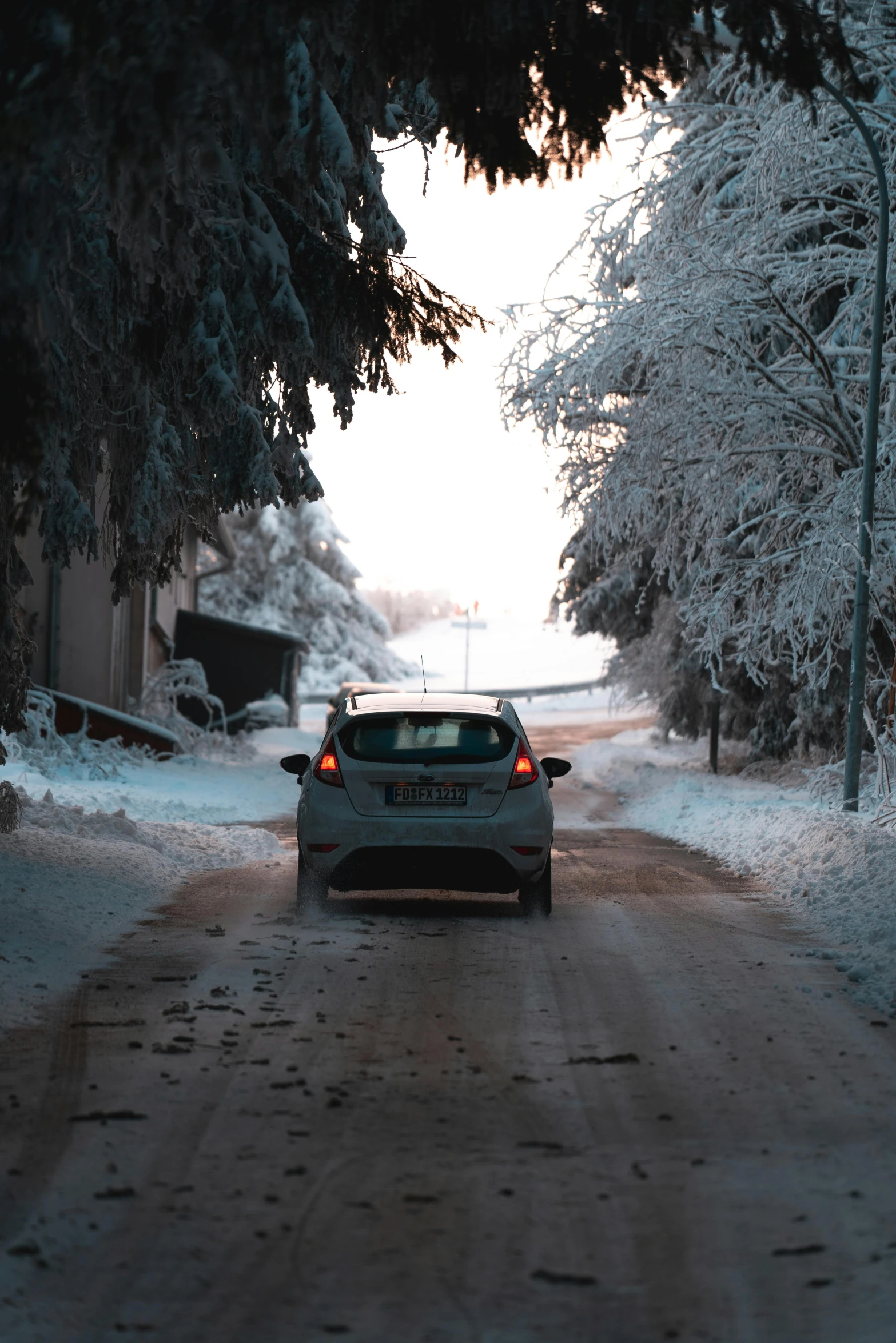 a car parked on a snowy road near some trees