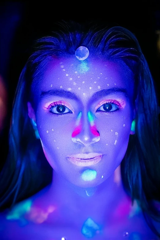 a woman is illuminated by a neon make up