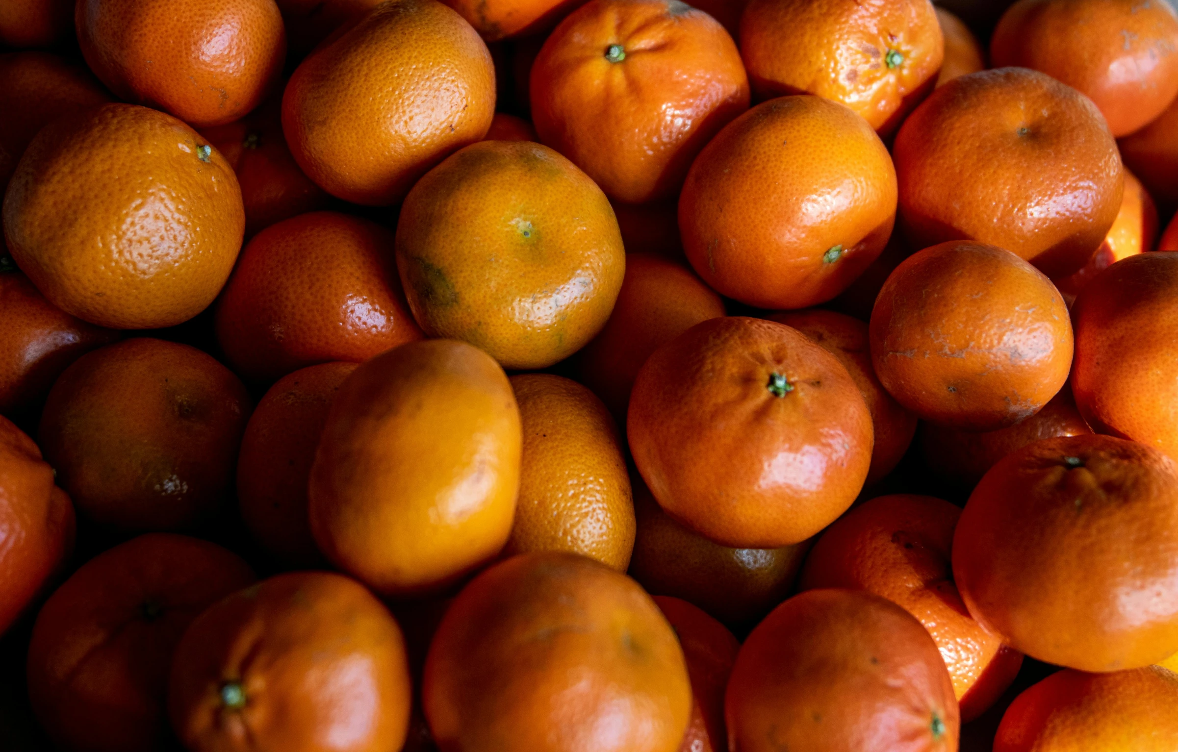 a pile of oranges with only one piece cut off