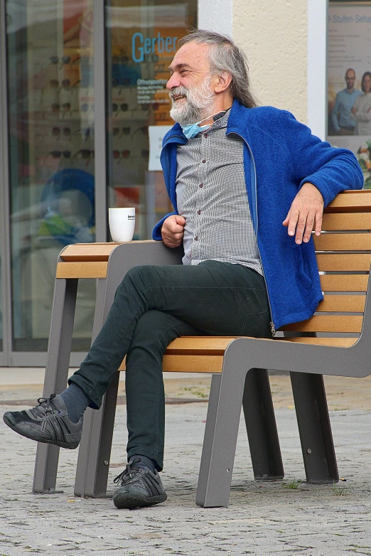 a person sitting on a bench in front of storefront