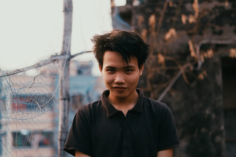 a young man looks at the camera with a dark shirt on