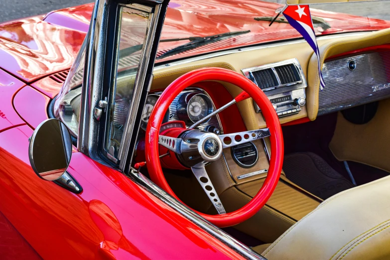 the interior of a classic car with the steering wheel and instrument mounted to the wall