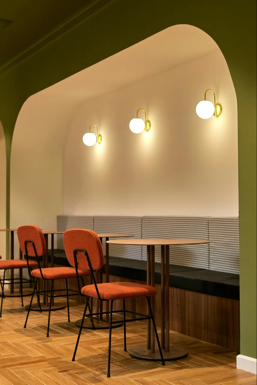 a restaurant table and chairs with lights mounted over them