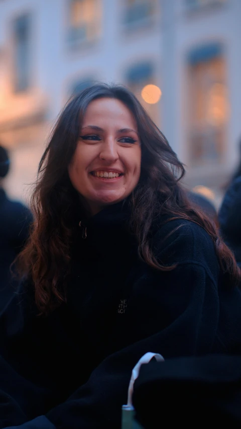 a woman is smiling and holding her cup