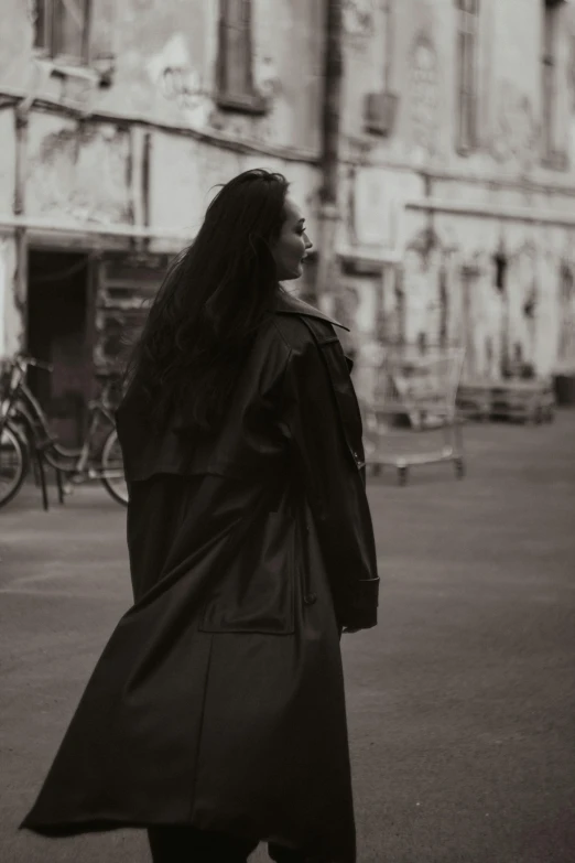 a young woman walking down the sidewalk with long hair