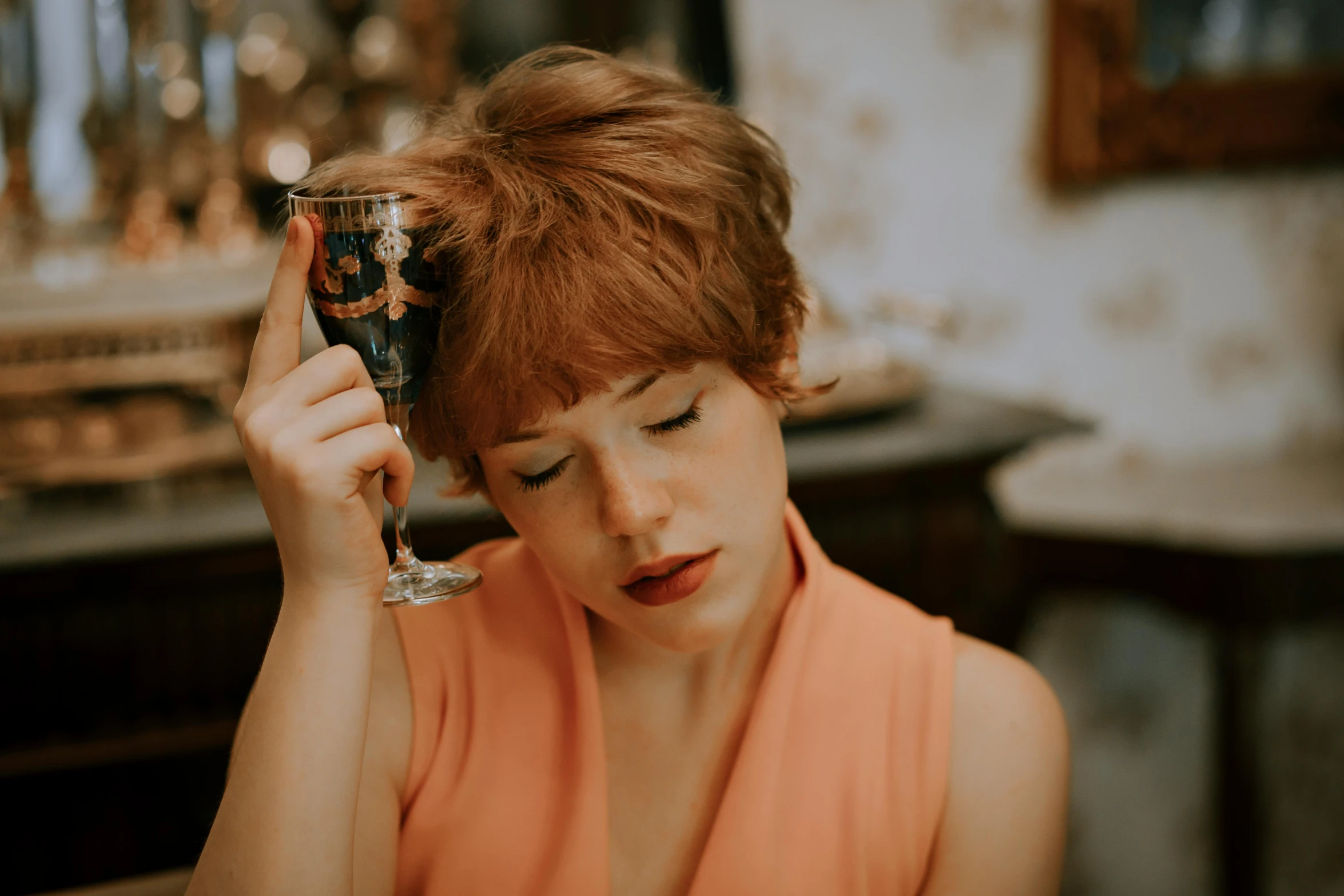 a young lady holding a wine glass in her hand