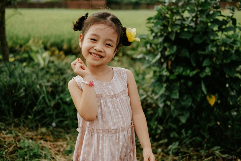 little girl with yellow flower in her hair posing