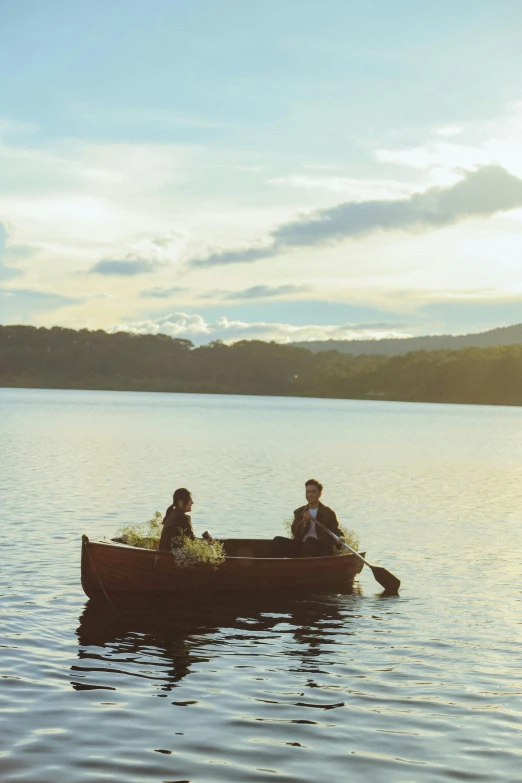 two people in a canoe with plants growing on the sides