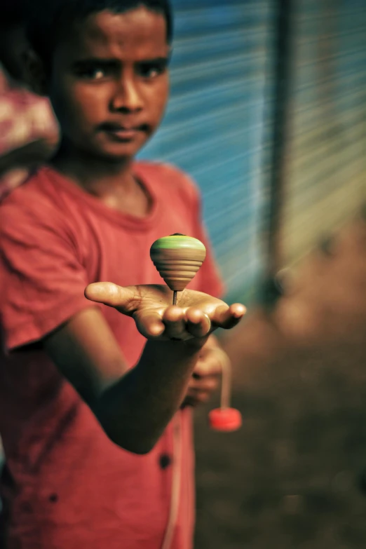 a boy holding soing with a green top