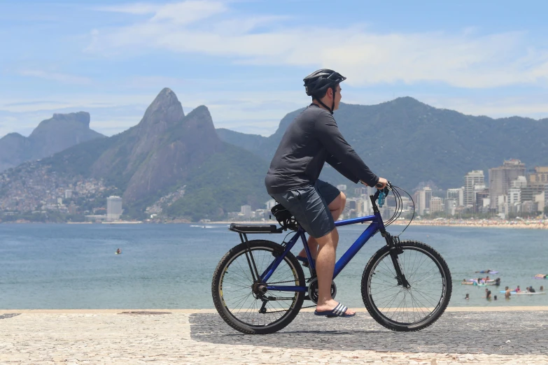 a person on a bicycle that is at the beach