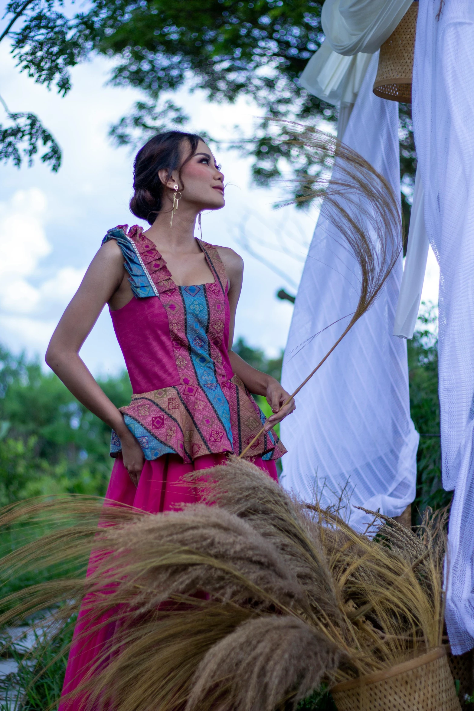 woman in a long pink dress standing in the sun