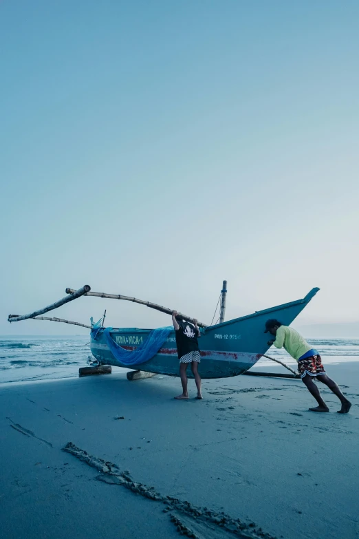 two men are doing tricks near a boat on the beach