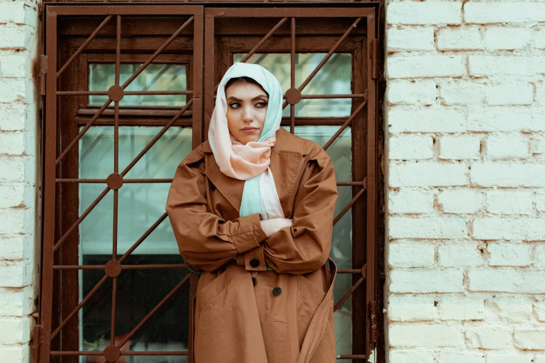 a person standing near a window in front of an iron fence