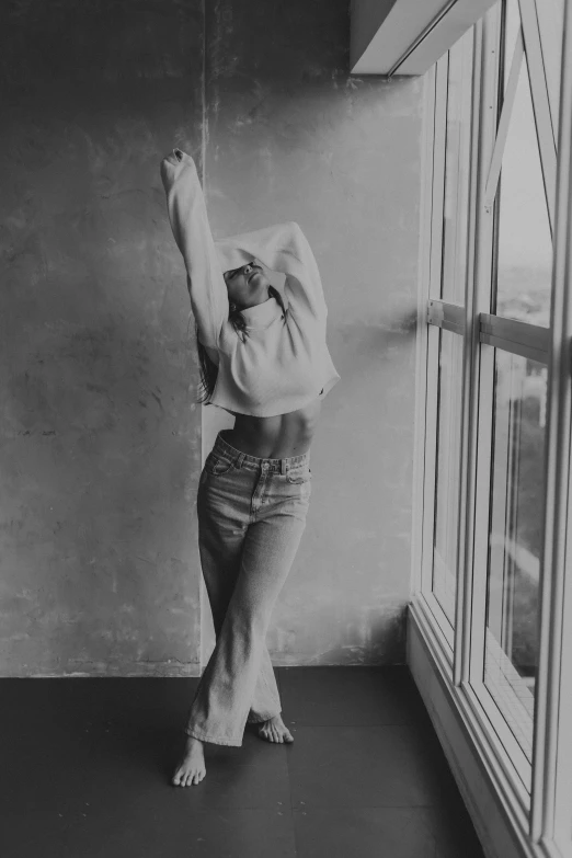 woman standing in front of windows with arm extended