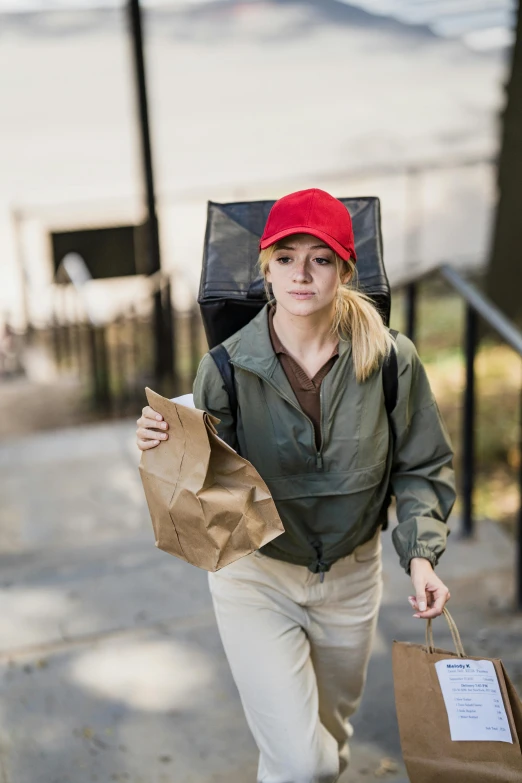 there is a woman holding shopping bags on the side of a sidewalk