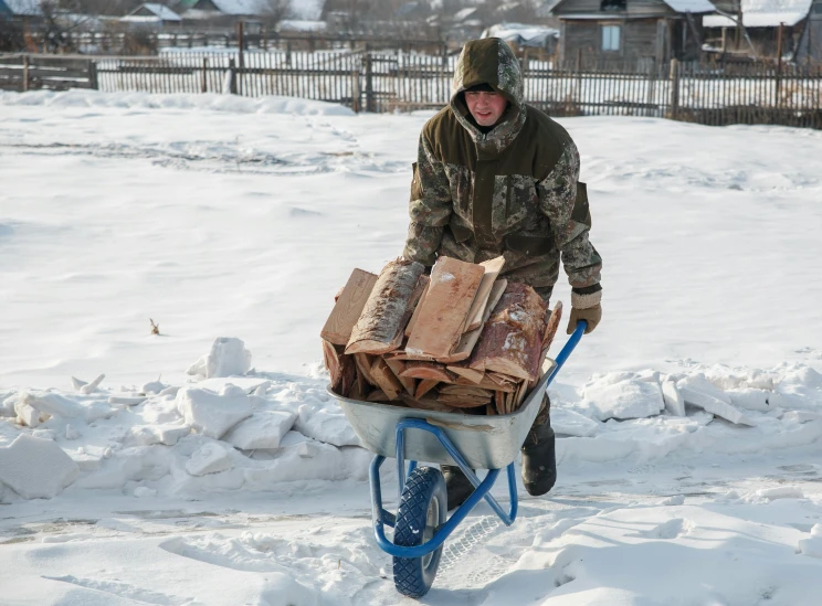 a man pulling a wheelbarrow filled with furniture