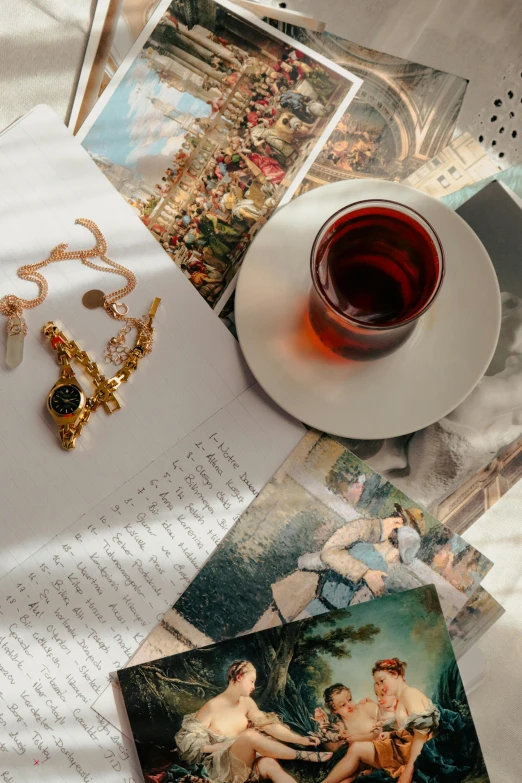 pictures, jewelry and a cup of tea on a table