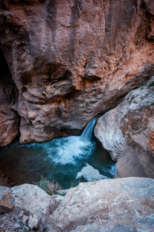 a small waterfall runs between large rocks