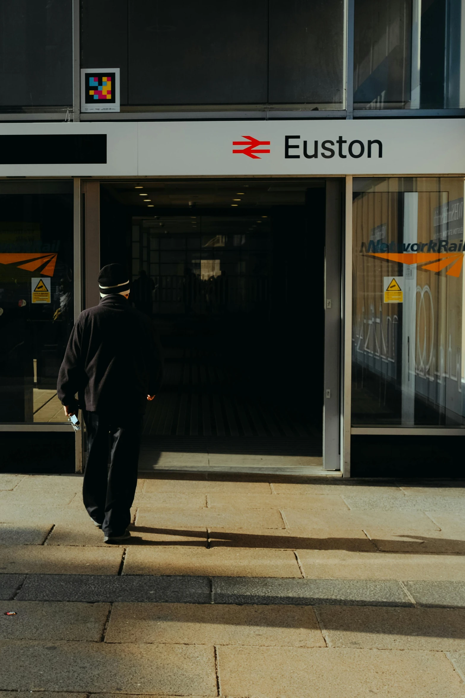 a person walking down the sidewalk near an exit