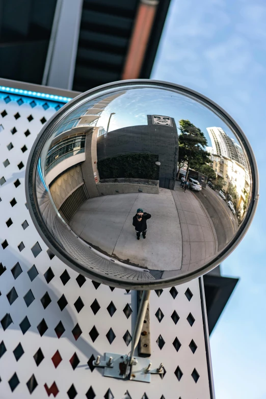 a person walking in the street while holding a hand bag and a rear view mirror