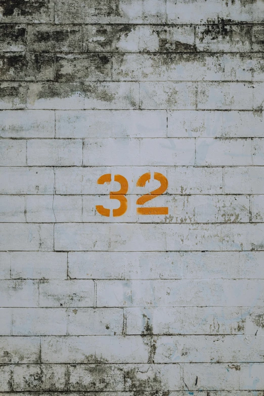 a cement block wall with orange numbers on it