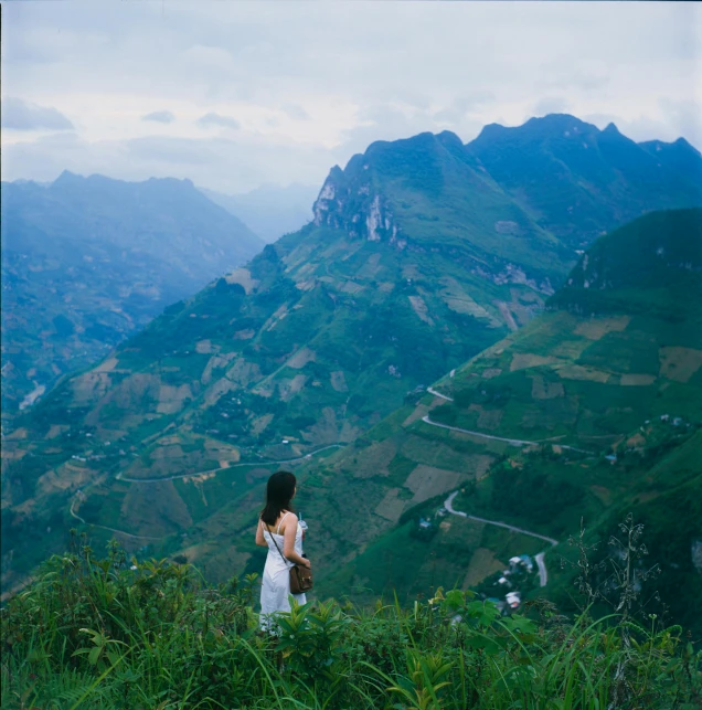 a woman with a backpack standing on top of a mountain