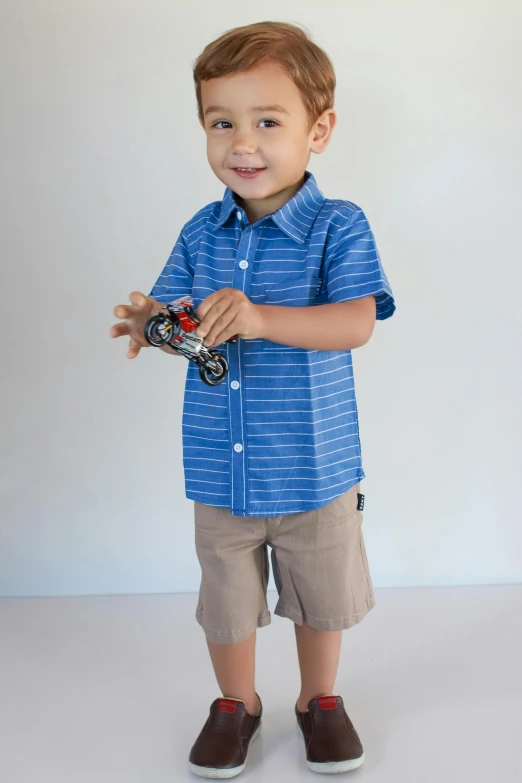 a small boy standing in a white background