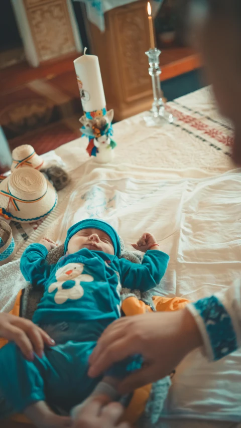 a baby lying in a crib with a white crochet blanket