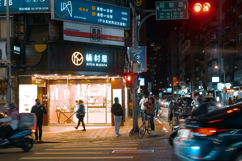 a store front is lit up and surrounded by cars