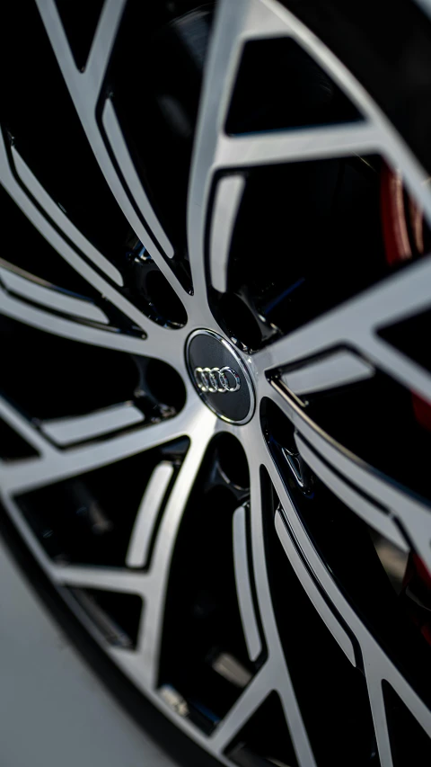 an interesting black rim with red spokes is featured on a car