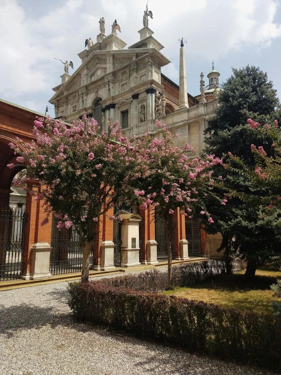 there is a building with pink flowers growing in front