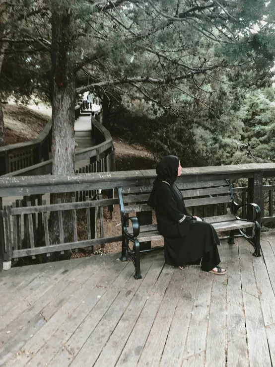 a woman in a veil and dress sitting on a bench