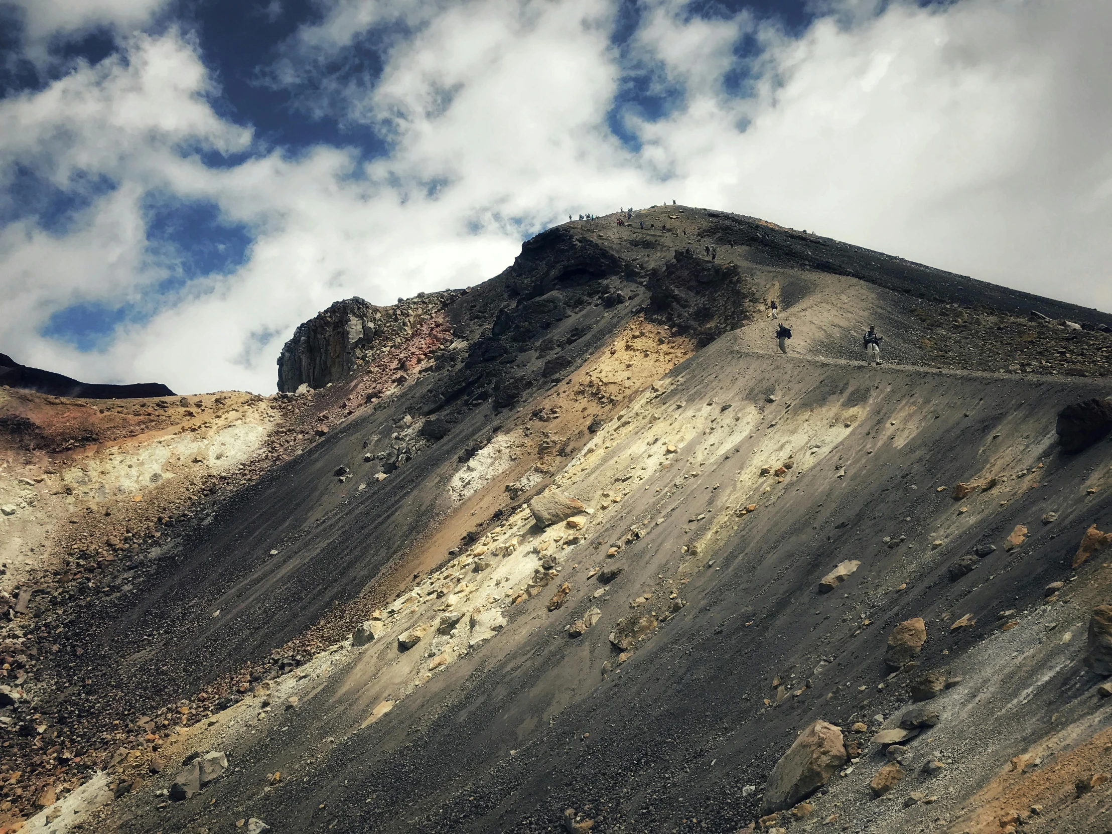 a dirt hill and some clouds in the sky