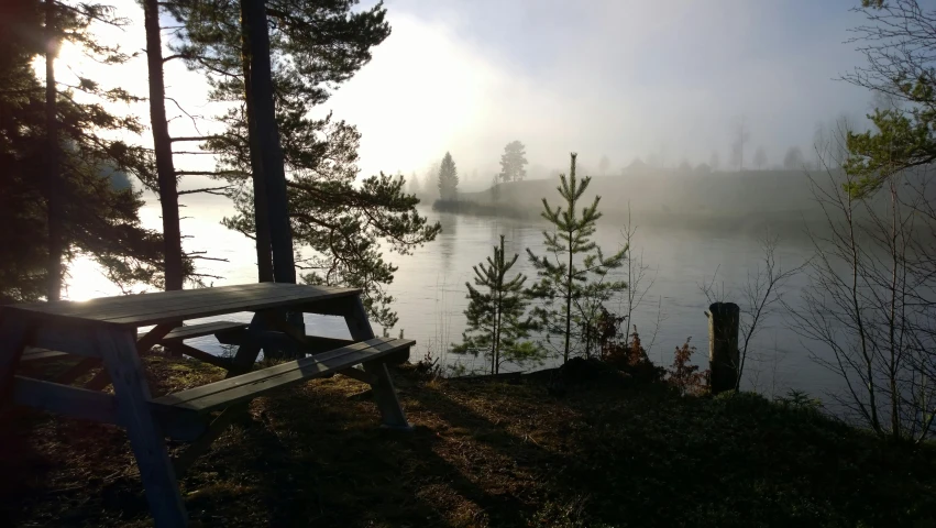 fog covers the water at a campsite near the shore