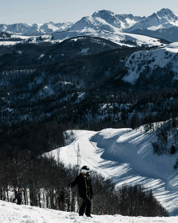 a lone snow boarder looks back at the view