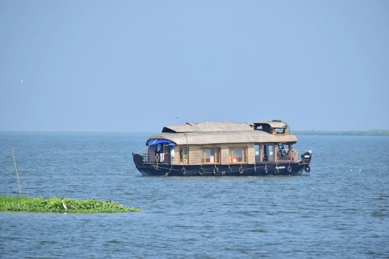 a house boat that is floating in the middle of the ocean