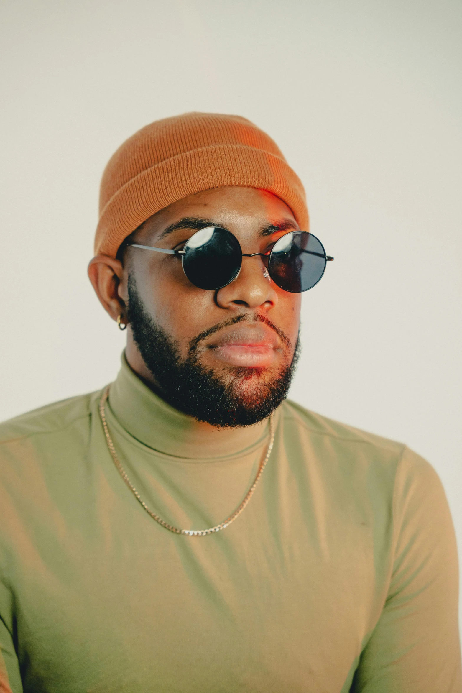 a man with sunglasses and a green shirt looking off in the distance