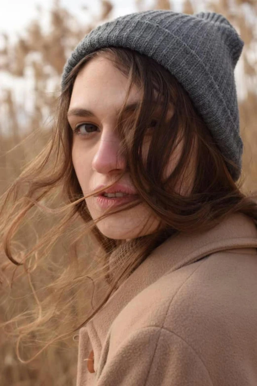 a woman is standing in a field with long hair