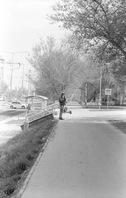 a man is walking down the street near a tree